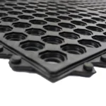 Angled view of a heavy-duty black honeycomb rubber mat.