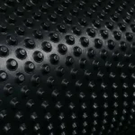 Angled view of textured black HDPE drainage mat