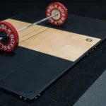 Barbell with red plates on a BLK BOX platform