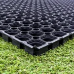 Black rubber drainage mat laid on green grass