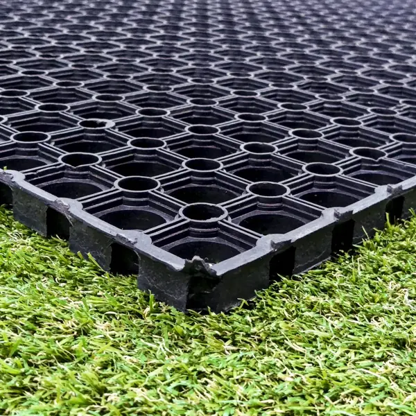 Black rubber drainage mat laid on green grass