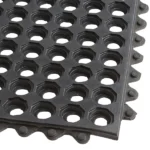 Close-up of black rubber mat with drainage holes and tabs