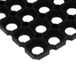 Corner detail of a black rubber honeycomb mat