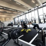 People training in a bright Adidas gym with sleds