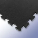 Stack of black interlocking rubber tiles with white flecks