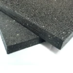 Two stacked rectangular rubber gym tiles illustrating thickness and durable surface texture