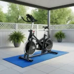 exercise bike placed on a blue protective rubber mat on an outdoor patio